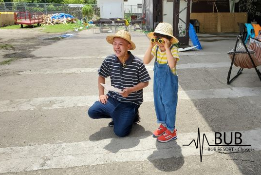 父親と子供が双眼鏡で覗いている写真